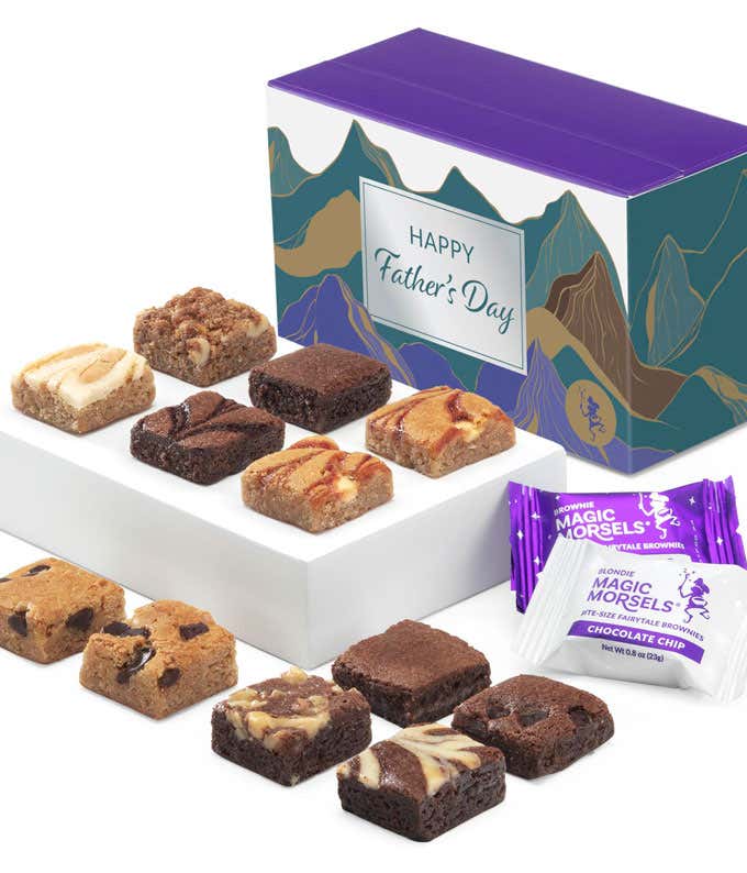 The image shows a box labeled 'Happy Father's Day' with a mountain design, filled with assorted brownies. The brownies are neatly arranged in two rows on a white tray, with various flavors and toppings visible. Two Magic Morsels packets are also included.