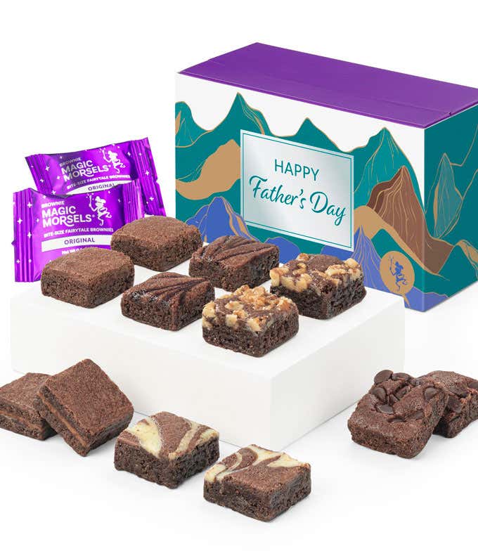 The image features a box labeled 'Happy Father's Day' with a mountain design, containing an assortment of chocolate brownies. The brownies are neatly arranged on a white tray, with different flavors and toppings visible. Two Magic Morsels packets are incl