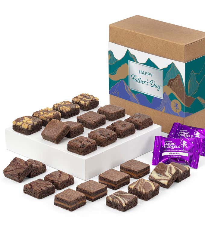The image shows a box labeled 'Happy Father's Day' with a mountain design, filled with assorted gourmet brownies. The brownies are arranged on a white tray in two rows, displaying various flavors and toppings. Two Magic Morsels packets are also present. 