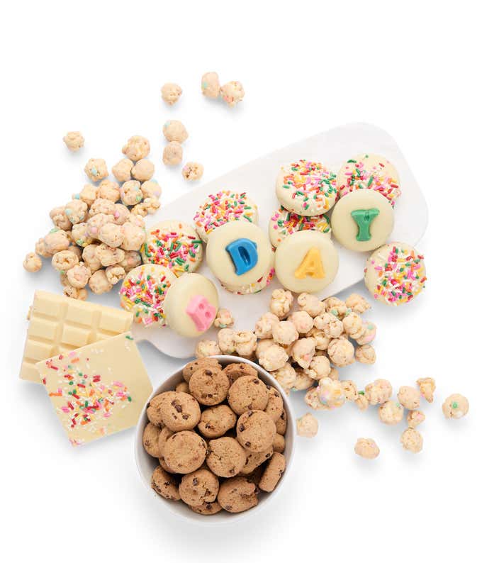 An assortment of birthday treats, includingchocolate covered cookies spelling 