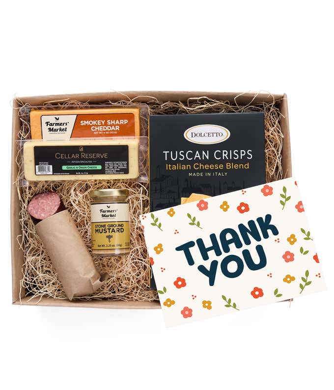 A charcuterie box with two types of cheese, crackers, stone-ground mustard, a summer sausage and a Thank You message card.