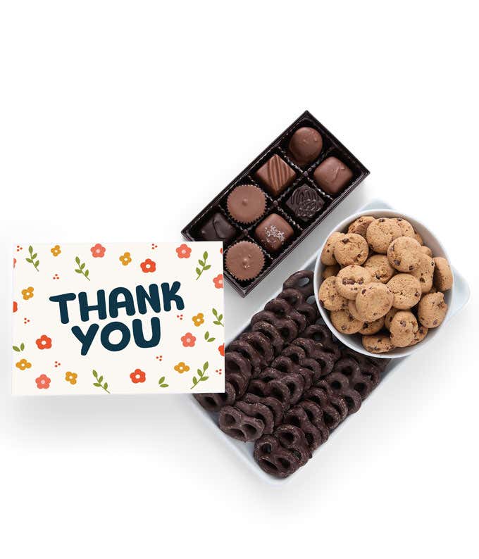 A selection of sweet treats, including a box of assorted chocolates, a box of mini chocolate chip cookies, and a bag of chocolate-covered pretzels accompanied by a Thank You message card for a personal touch.