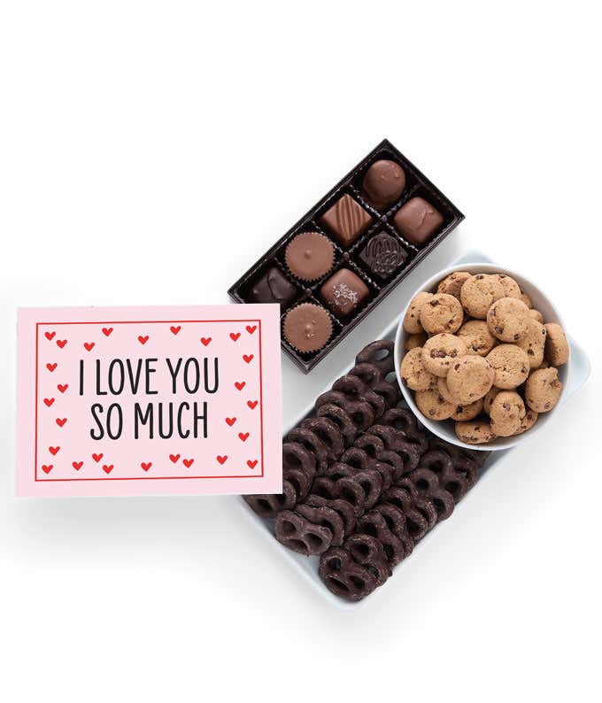 A selection of sweet treats, including a box of assorted chocolates, a box of mini chocolate chip cookies, and a bag of chocolate-covered pretzels accompanied by an I Love You message card for a personal touch.