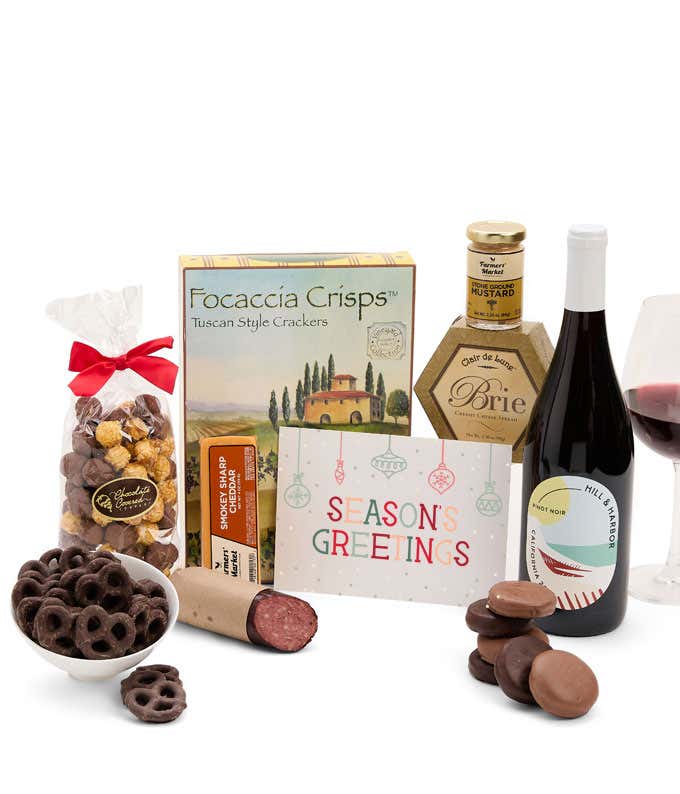 A gift set with a bottle of California Pinot Noir, focaccia crisps, two cheeses, mustard, summer sausage, caramel popcorn, chocolate pretzels, six chocolate-covered Oreos and a Season's Greetings card to complete the gourmet experience.