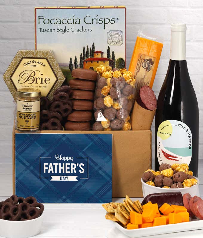 A bottle of Hill & Harbor Pinot Noir with focaccia crisps, 2 cheeses, mustard, sausage, chocolate-covered pretzels, caramel popcorn, and chocolate-covered Oreos, complete with a 'Happy Father's Day' card.