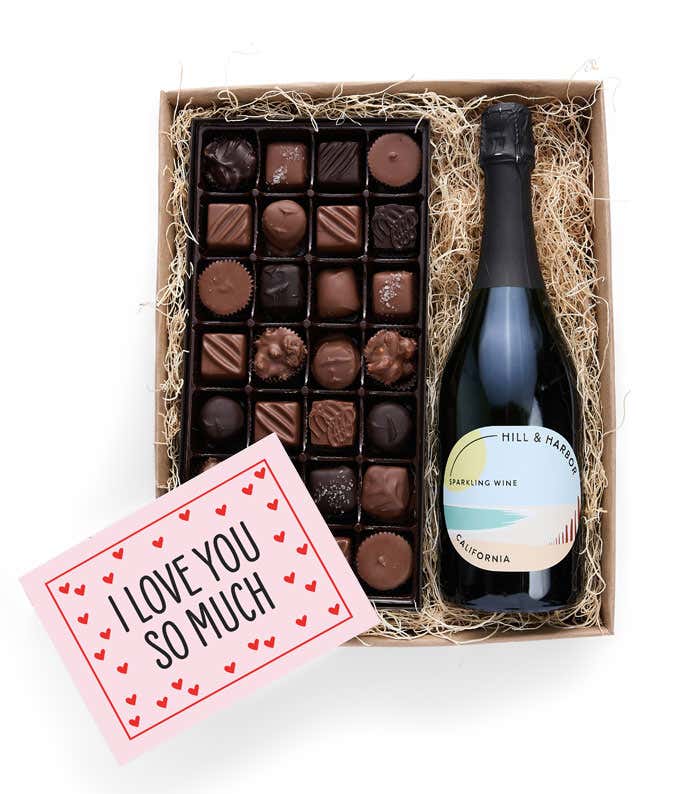 A gift box containing a bottle of California Sparkling wine by Hill & Harbor, a 1 lb box of 28 assorted gourmet chocolates in a grid, and a Season's Greetings message card.   A refined combination perfect for holiday gatherings.