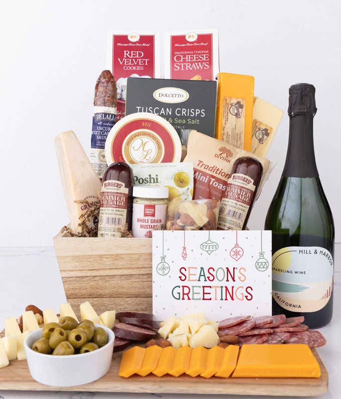 Wooden basket filled with 4 cheeses, 3 sausages, crackers, cookies, nuts, mustard, olives and crisps alongside a bottle of Hill & Harbor Sparkling Wine and Season's Greetings message.