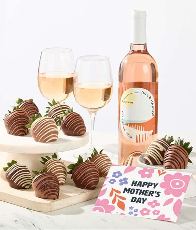 Hill & Harbor rosé wine bottle displayed with two glasses and assorted chocolate-covered strawberries on trays, styled with a floral Happy Mother’s Day card for a fresh wine and dessert gift.