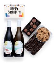 A birthday gift set with two bottles of Hill & Harbor wine (Pinot Noir and Chardonnay), a box of assorted chocolates, a tray of chocolate-covered pretzels, a bowl of mini chocolate chip cookies, and a birthday message card.