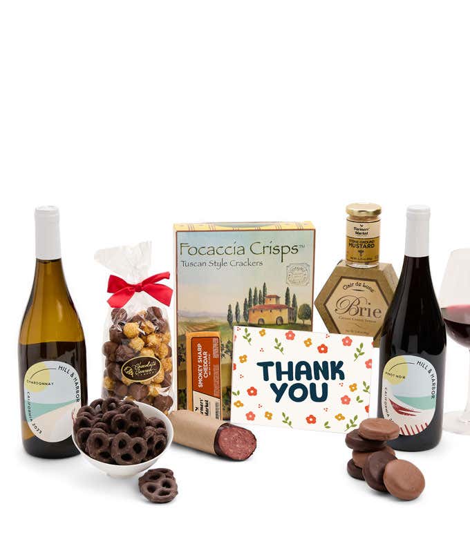 A gift set featuring two bottles of Hill & Harbor wine - white and red, focaccia crisps, two cheeses, mustard, summer sausage, caramel popcorn, chocolate pretzels, six chocolate-covered Oreos and a Thank You card to complete the gourmet experience.