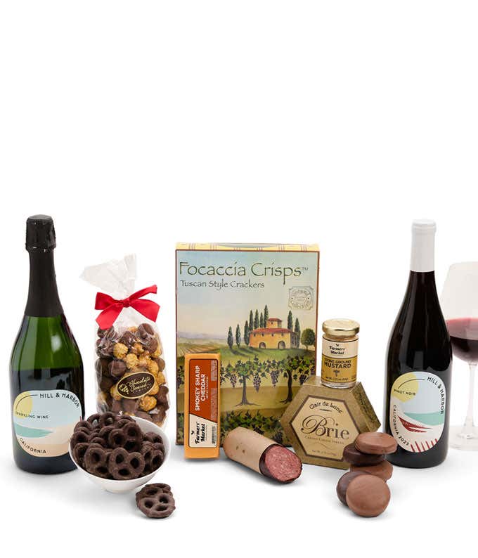 A gift set featuring 2 bottles of Hill & Harbor wine - red and sparkling, focaccia crisps, 2 cheeses, mustard, summer sausage, caramel popcorn, chocolate pretzels, and 6 chocolate-covered Oreos for a sweet and savory gourmet experience.