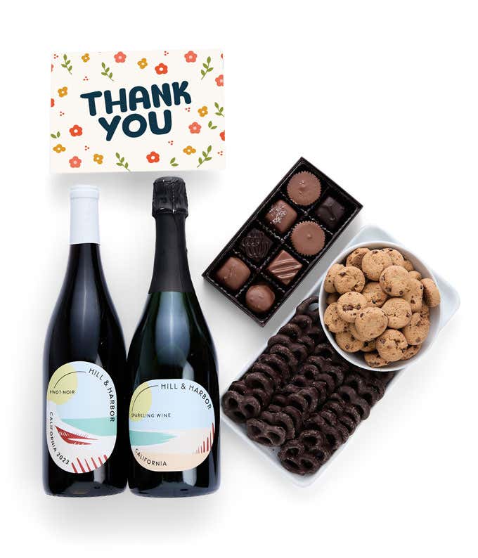 a gift box full of  treats with a Thank You message card.  Contents include: two bottles of California wine - Pinot Noir and Sparkling Wine, milk chocolate pretzel, a box of mini chocolate chip cookies, and a 4-ounce box of assorted chocolates.