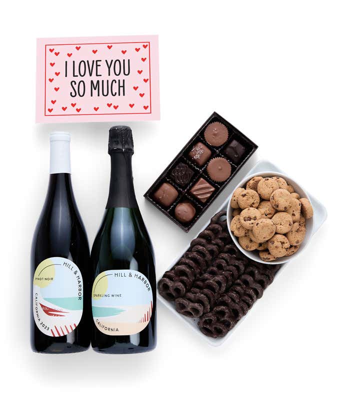 a gift box full of treats with an I Love You message card.  Contents include: two bottles of California wine - Pinot Noir and Sparkling Wine, milk chocolate pretzel, a box of mini chocolate chip cookies, and a 4-ounce box of assorted chocolates.