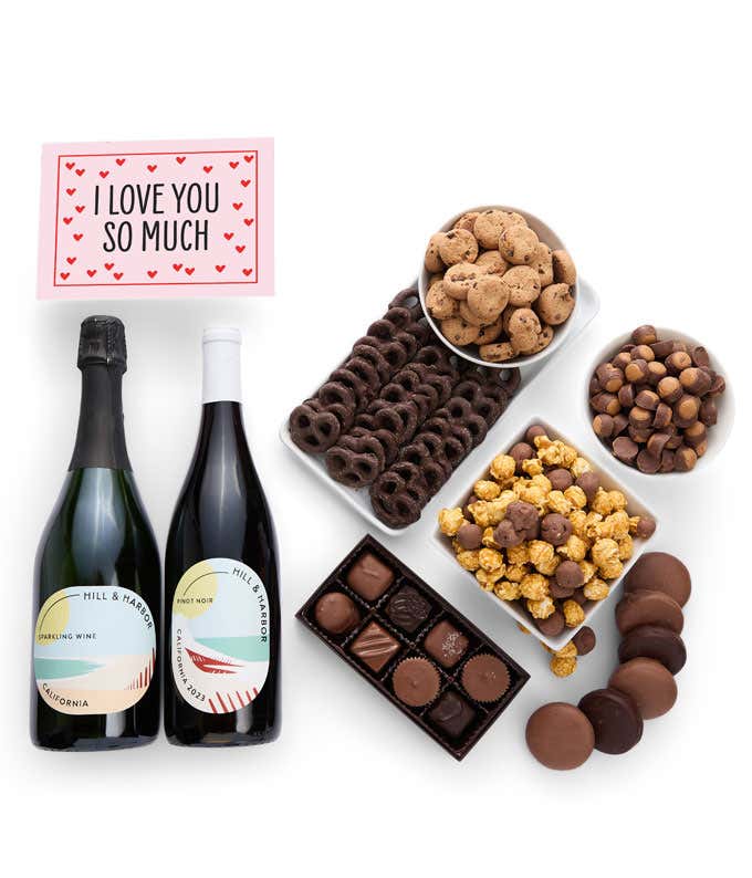 A gift set with 2 bottles of wine - red and sparkling, paired with chocolate pretzels, caramel popcorn, mini cookies, chocolate peanut butter buckeyes, six chocolate-covered Oreos, assorted chocolates, and a touching 'I Love You' card.