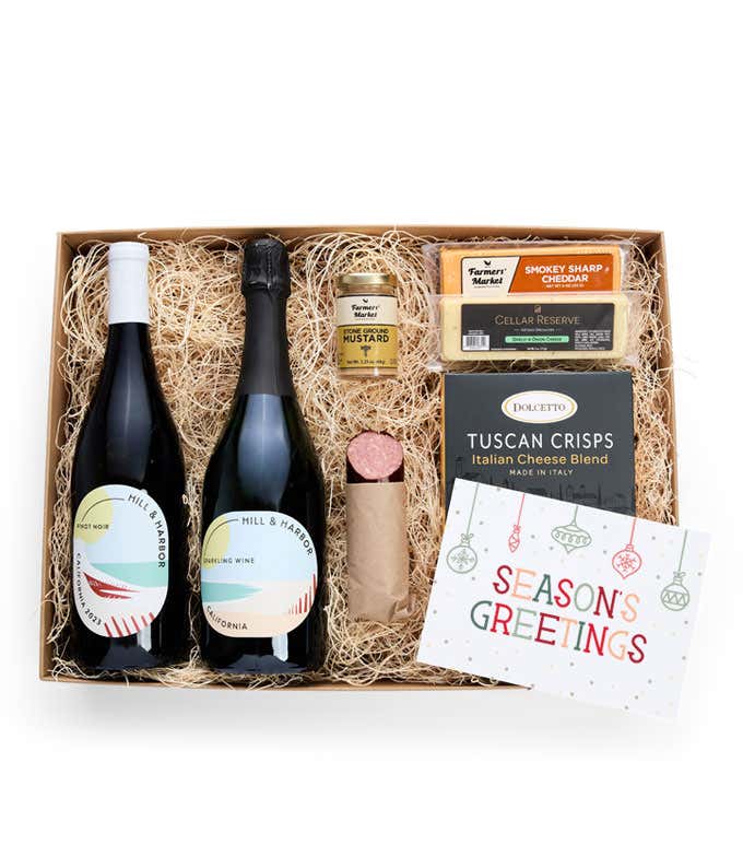 A gift box with two bottles of California wine (Pinot Noir and Sparkling Wine), two types of cheese, crackers, stone-ground mustard, a summer sausage, and a 'Season's Greetings' card.