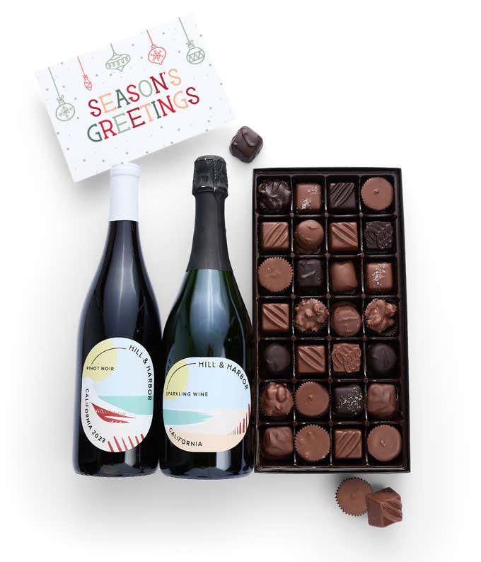 A gift box containing two bottles of California Wine - Pinot Noir & Sparkling Wine, a 1 lb box of 28 assorted gourmet chocolates in a grid, and a Season's Greetings message card.   A refined combination perfect for holiday gatherings.