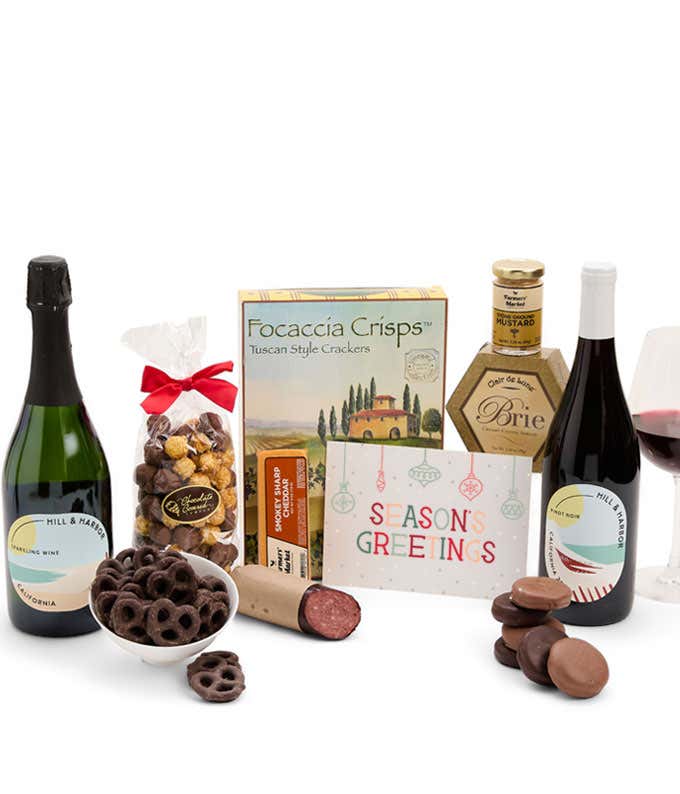 A gift set featuring 2 bottles of Hill & Harbor wine - red and sparkling, focaccia crisps, two cheeses, mustard, sausage, caramel popcorn, chocolate pretzels, six chocolate-covered Oreos and a Season's Greetings card to complete the gourmet experience.