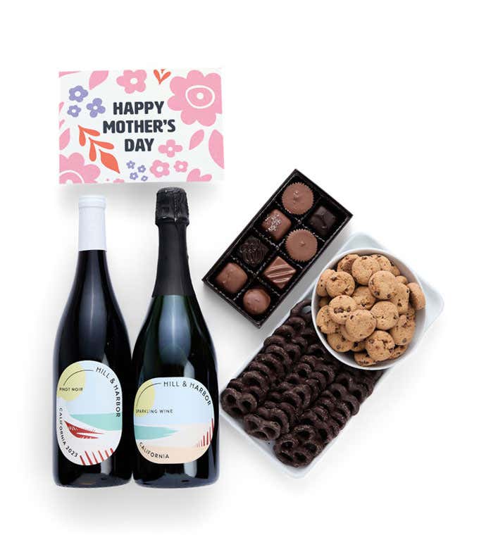 Bottles of Hill & Harbor Pinot Noir and Sparkling wine paired with chocolate covered pretzels, mini chocolate chip cookies, a box of chocolates, and a 'Happy Mother's Day' card.