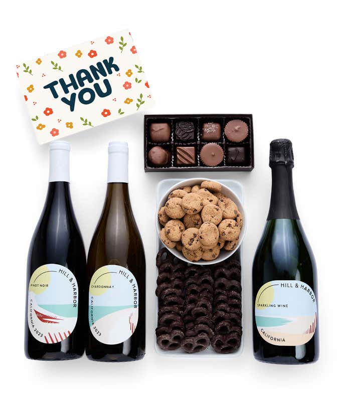 A Thank You gift set with three bottles of Hill & Harbor wine (Pinot Noir, Chardonnay, and sparkling wine), a box of assorted chocolates, chocolate-covered pretzels, a box of mini chocolate chip cookies, and a Thank You greeting card.