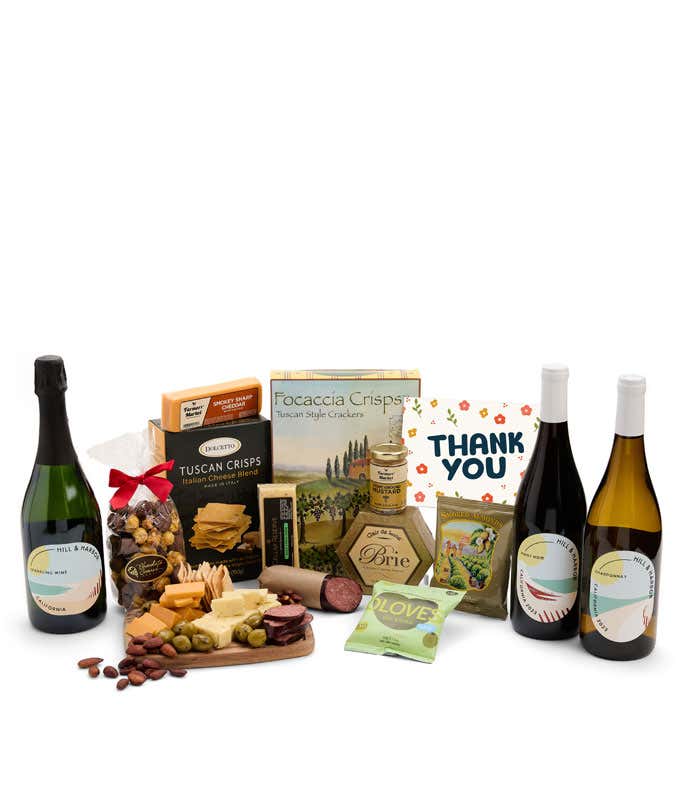 A wine and cheese gift set featuring bottles of Hill & Harbor sparkling wine, Chardonnay, and Pinot Noir. Includes a variety of gourmet cheeses, crackers, olives, summer sausage, almonds, salami, and condiments finished with a Thank You card.