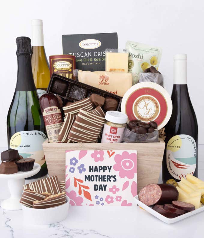 Wooden Mother’s Day gift crate filled with three bottles of Hill & Harbor wine, summer sausage, brie, cheeses, Tuscan crisps, chocolates, pretzels, and gourmet snacks, displayed with a Mother’s Day card.