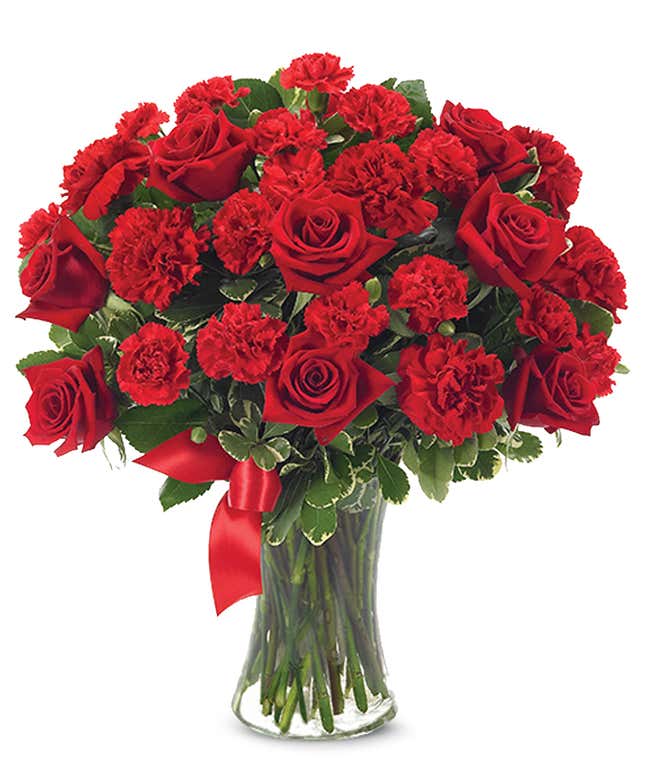 红玫瑰和康乃馨插在玻璃花瓶里