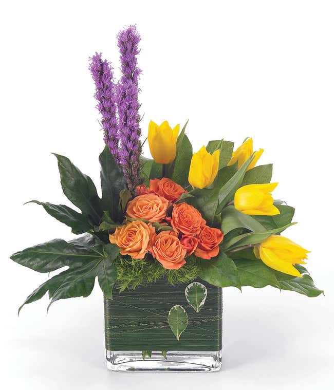 Yellow tulips and orange roses in square vase