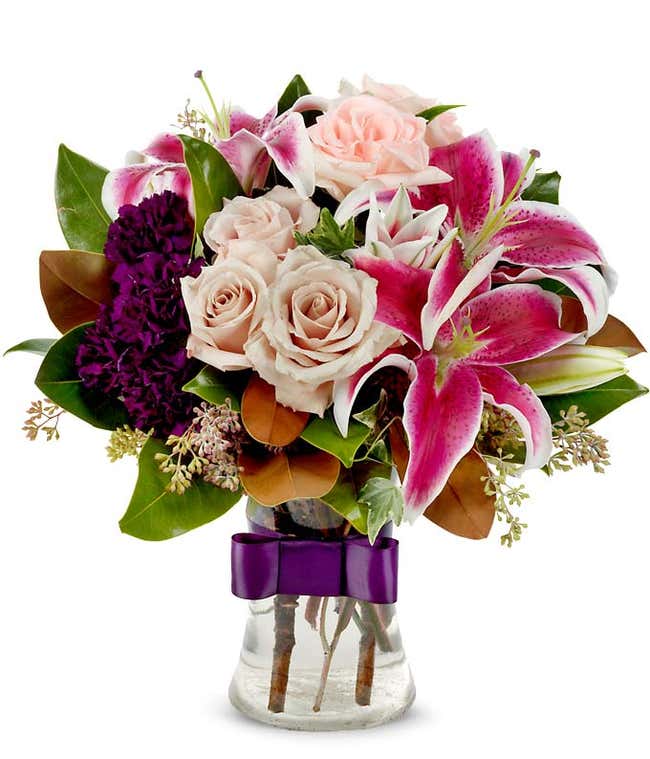 Pink stargazer lilies, cream roses and purple carnation bouquet