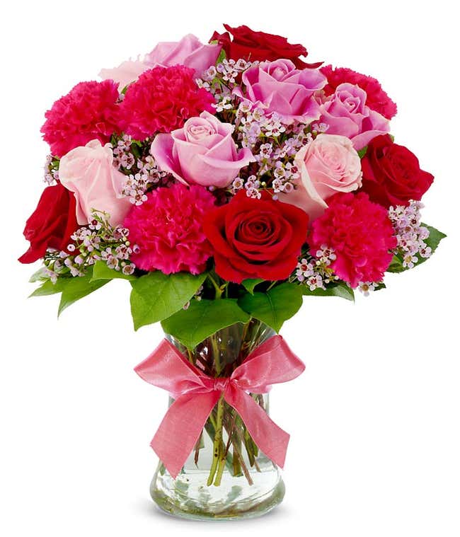 Pink roses, red roses and pink carnations in glass vase