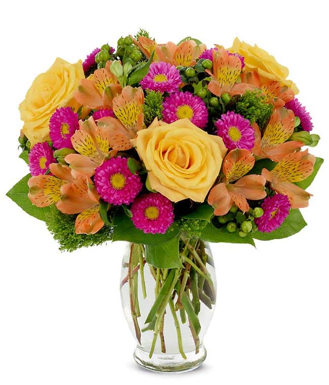 Spring bouquet with hot pink asters, yellow roses and green hypericum
