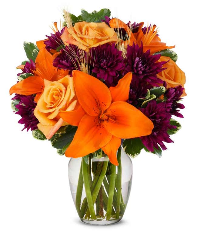 Flower arrangement with orange lilies, orange roses and purple flowers