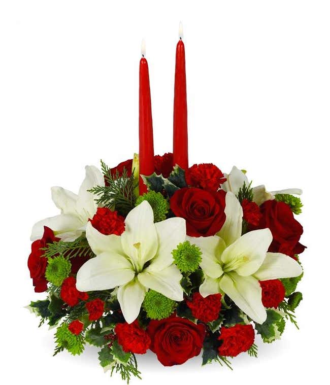 White lilies and red carnation holiday centerpiece with tapered candles