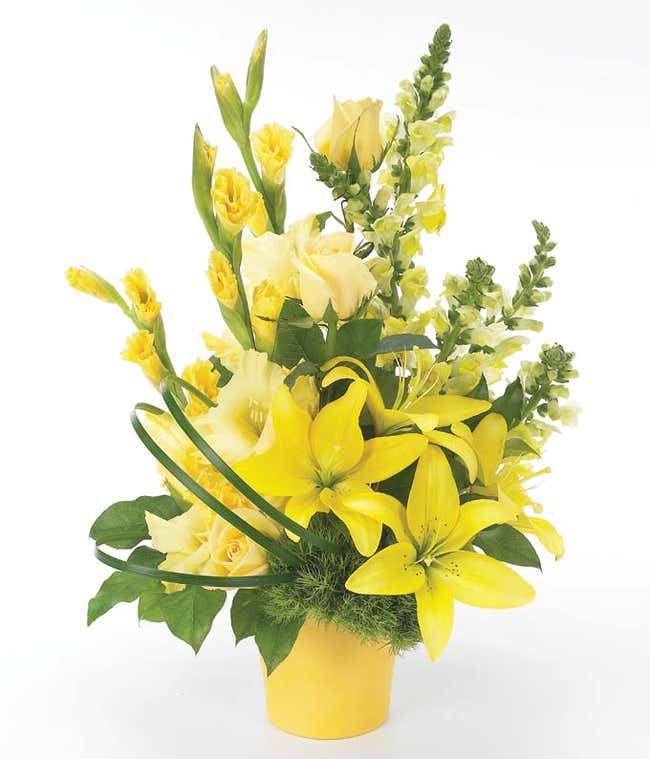Yellow and green roses and lilies in yellow vase