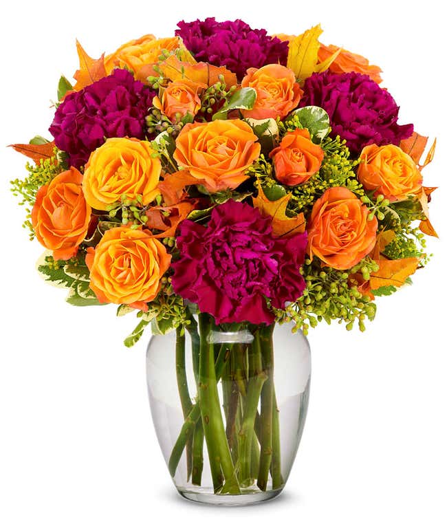 Deep purple carnations arranged with orange spray roses