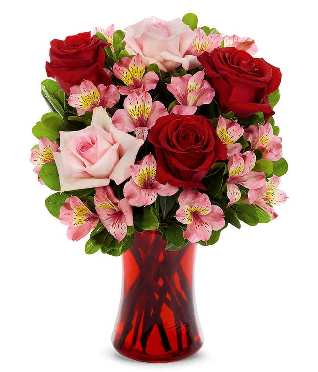 Red roses, pink roses and pink alstroemeria in a red vase