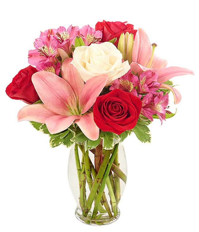 Cute romantic flower arrangement with red roses, pink lilies and white lilies