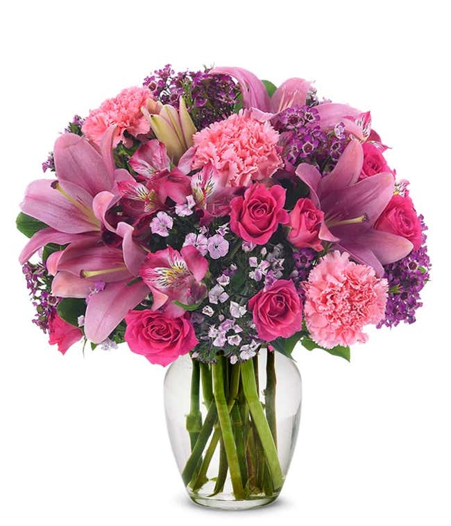 Pink carnations, pink spray roses and pink lilies in pink vase
