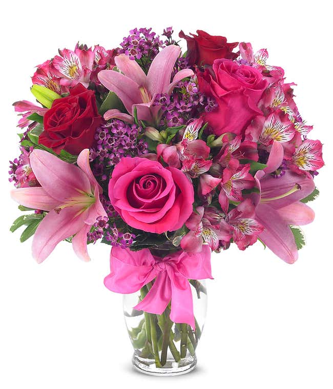 红色的玫瑰，粉色的百合，粉色的仙仙花和玻璃花瓶