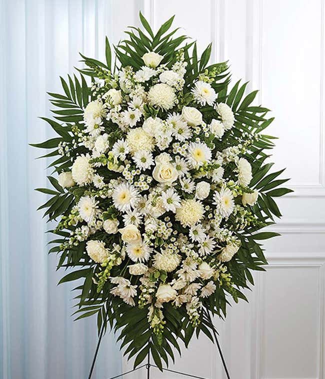 Standing spray with white roses, football mums and snapdragons