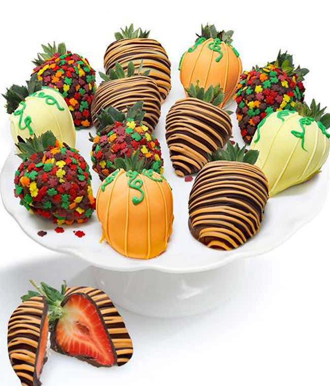 A dozen large strawberries dipped in milk, dark, and white chocolate, adorned with fall-themed sprinkles and chocolate orange drizzle.