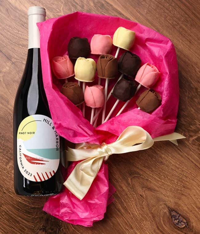 A bouquet of Belgian chocolate roses in milk, dark, and white chocolate, wrapped in pink tissue paper and tied with a cream ribbon, accompanied by a bottle of Hill &amp; Harbor Pinot Noir
