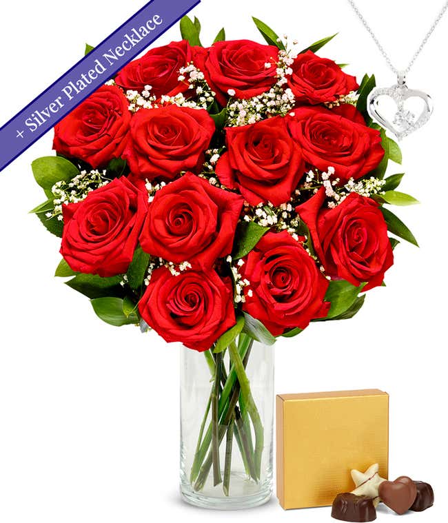 One dozen red roses with a silver heart necklace on a chain and a small box of assorted chocolates