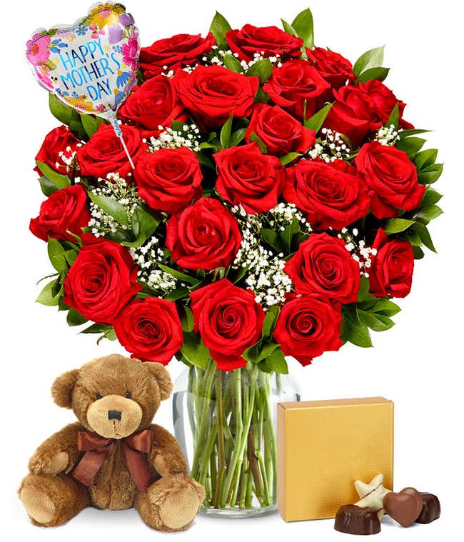 Two dozen red roses with greenery and baby's breath in a clear glass vase. Sat next to it is a brown teddy bear and a brown &amp; gold square box of chocolates. And a pink and red heart shaped balloon reading happy mother's day