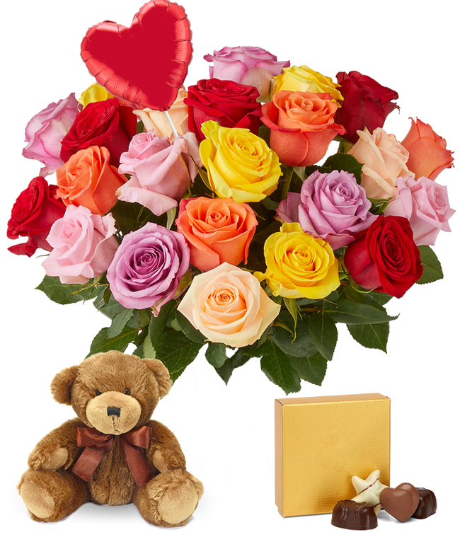 Partial image of Two dozen roses red, orange, yellow, cream, pink, and lavender blooms with green leaves in a clear vase. Sat next to it is a brown teddy bear and a gold square box of chocolates with a red heart shaped balloon without vase.