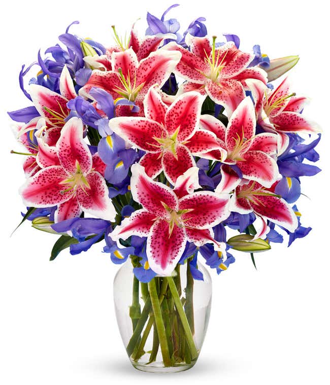 A bouquet of Iris &amp; Stargazer Lilies in a Glass Vase