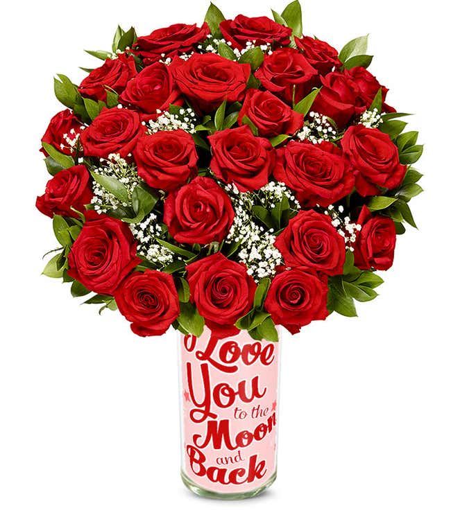 a bouquet of 24 red roses with small white flowers and greenery in between in a clear glass vase