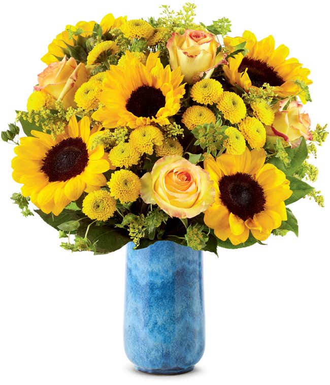 A vibrant arrangement featuring yellow/orange bi-color roses, sunflowers, yellow button poms, yellow solidago, and bupleurum, optionally presented in a vase. This cheerful display brings a burst of sunshine and joy to any occasion.