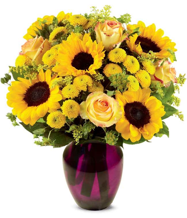 A vibrant arrangement featuring yellow/orange bi-color roses, sunflowers, yellow button poms, yellow solidago, and bupleurum, optionally presented in a vase. This cheerful display brings a burst of sunshine and joy to any occasion.
