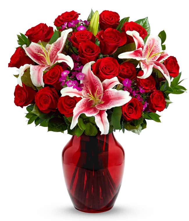 18 red roses, Stargazer lilies, pink dianthus, floral greens, optional glass vase.