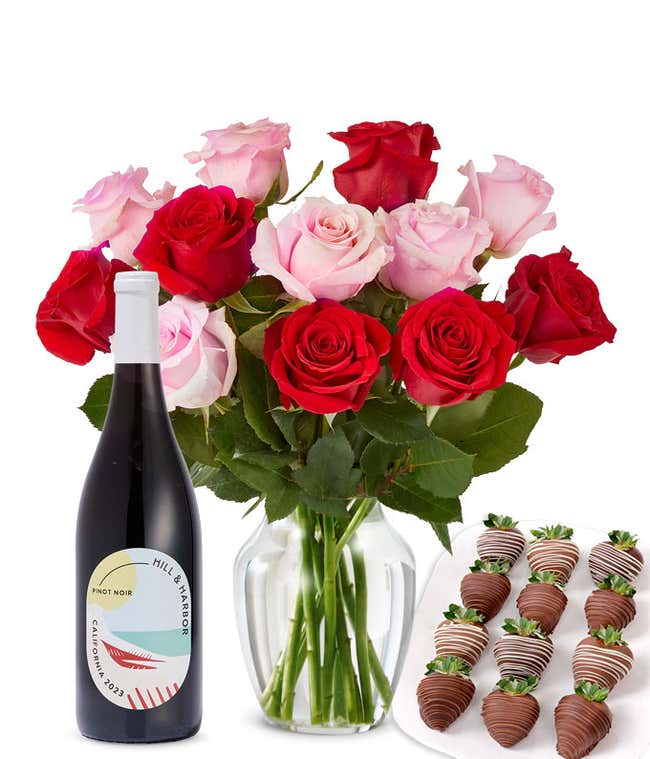 A mixed bouquet of 1 dozen red and blush roses in a clear vase is paired with a bottle of Hill &amp; Harbor Pinot Noir and 12 chocolate-covered strawberries.